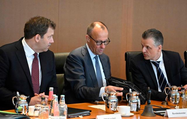 German Chancellor Friedrich Merz (C) sits between German Finance Minister and Vice Chancellor Lars Klingbeil (L) and Chief of Staff and Minister for Special Tasks Thorsten Frei (R) as they prepare for the weekly meeting of the German cabinet at the chancellery in Berlin on May 6, 2026. (Photo by Tobias SCHWARZ / AFP)