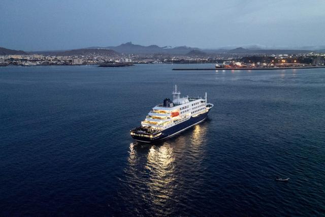 A general view of the cruise ship MV Hondius, while stationary off the port of Praia, the capital of Cape Verde, on May 6, 2026. Two seriously ill crew members on a cruise ship stricken by a deadly hantavirus outbreak will be evacuated via Cape Verde to the Netherlands, allowing the vessel to sail on to Spain's Canary Islands, the ship operator said on May 5, 2026.
The MV Hondius has been at the centre of an international health scare since Saturday, when WHO was informed that the rare disease -- usually spread from infected rodents typically through urine, droppings and saliva -- was suspected of being behind the deaths of three of its passengers.
As others fell ill, passengers and crew have been in isolation after Cape Verde authorities barred the ship from docking, and as health authorities scrambled to find a port that would take the Hondius. (Photo by AFP)