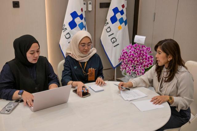 Indonesia's Communication and Digital Affairs Minister Meutya Hafid (R) speaks with Media Ecosystem Director Farida Dewi Maharani (C) and expert staff Sarah Syafitri (L) during a meeting at her official residence in Jakarta on May 6, 2026. Indonesia's government is mulling an e-commerce ban for under-16s, the communications minister told AFP on May 6, hot on the heels of Jakarta imposing a sweeping social media prohibition for teens. (Photo by BAY ISMOYO / AFP) / To go with AFP story Indonesia-internet-children,INTERVIEW by Marchio Gorbiano
