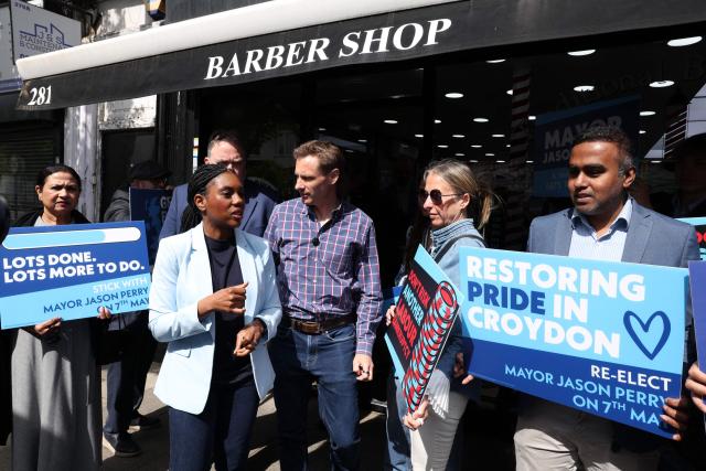 Britain's main opposition Conservative Party leader Kemi Badenoch (2L) stands with Britain's main opposition Conservative Party Shadow Home Secretary Chris Philp (C), and Conservative candidate for Mayor of Croydon, Jason Sperry (3L), as she undertakes a "branded taxi tour" at various points across the capital, in Croydon, south London on May 6, 2026, visiting key areas a day before British local elections. British voters head to the polls on May 7 for local elections set to pile more misery on unpopular Labour Prime Minister Keir Starmer and cement the rise of right- and left-wing populists. (Photo by Adrian DENNIS / AFP)