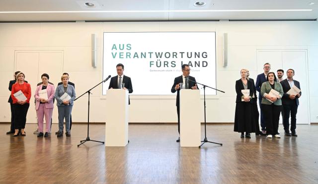 Cem Oezdemir (C-R) of the Greens and Manuel Hagel (C-L), chairman of the Christian Democratic Union (CDU) party in the southern federal state of Baden-Wuerttemberg, address the press to present their coalition contract following the federal state's elections, in Stuttgart, southern Germany, on May 6, 2026. (Photo by THOMAS KIENZLE / AFP)