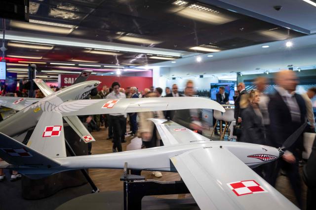 Participants pass by the stands at the "Defence24 Days" – a conference on defence and security attended by various leaders and experts from the region, in Warsaw, Poland, on May 6, 2026. (Photo by Wojtek RADWANSKI / AFP)