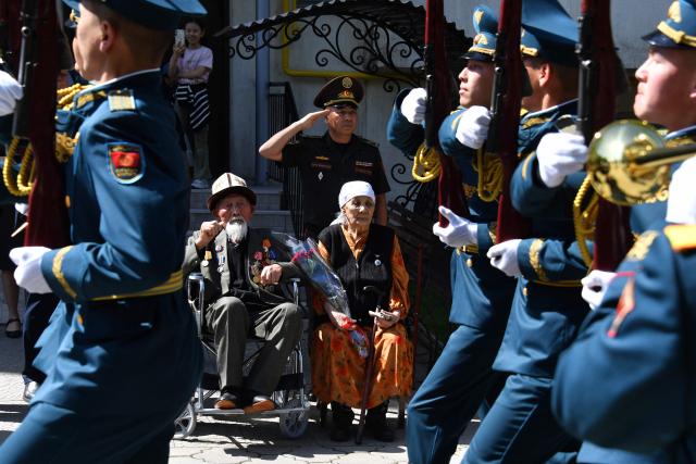 World War Two veteran Aspek Dumashev, 102, receives congratulations from Kyrgyz servicemen as part of the Victory Day celebrations in Bishkek on May 6, 2026. Kyrgyzstan will celebrate the 81st anniversary of the Soviet Union's victory over Nazi Germany on May 9. (Photo by Vyacheslav OSELEDKO / AFP)