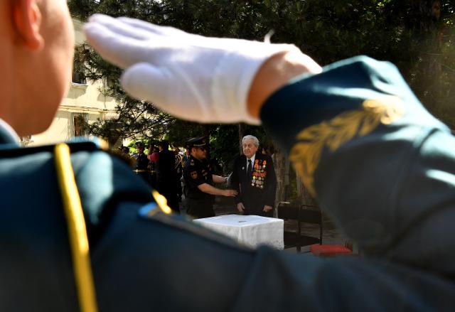 World War Two veteran Mikhail Sukhinin, 99, receives congratulations from Kyrgyz servicemen as part of the Victory Day celebrations in Bishkek on May 6, 2026. Kyrgyzstan will celebrate the 81st anniversary of the Soviet Union's victory over Nazi Germany on May 9. (Photo by Vyacheslav OSELEDKO / AFP)