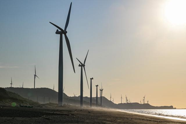 Wind turbines are pictured along the shore in Bangui in the northern Philippines province of Ilocos Norte on May 6, 2026. (Photo by Jam STA ROSA / AFP)