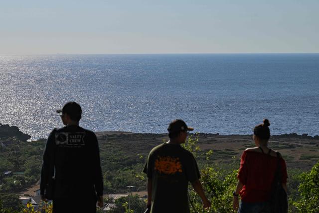 People look at the view of South China Sea in Burgos in the northern Philippines province of Ilocos Norte on May 6, 2026. (Photo by Jam STA ROSA / AFP)