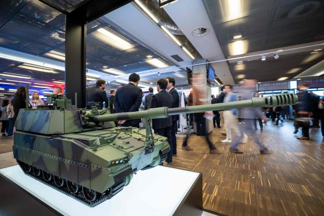 Participants walk past a mockup of the Korean-made K9 Thunder howitzer during the "Defence24 Days" – a conference on defence and security attended by various leaders and experts from the region, in Warsaw, Poland, on May 6, 2026. (Photo by Wojtek RADWANSKI / AFP)