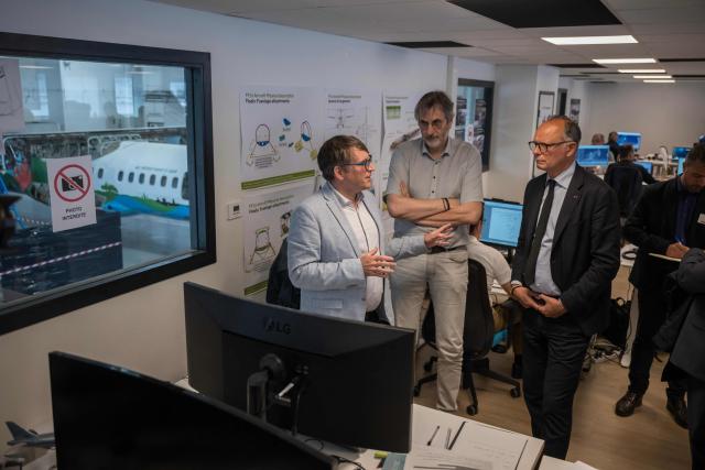 Mayor of Le Havre Edouard Philippe (R) talks with Positive Aviation founder and president Laurent Schmitt (L) during a visit to the aerospace company's hangar in Blagnac, on the outskirts of Toulouse, on May 6, 2026. The company is developing the FF72, a firefighting aircraft based on modified ATR 72 turboprops, with a demonstrator currently assembled at its Toulouse-Blagnac Airport hangar ahead of a planned first flight in 2026. (Photo by Ed JONES / AFP)