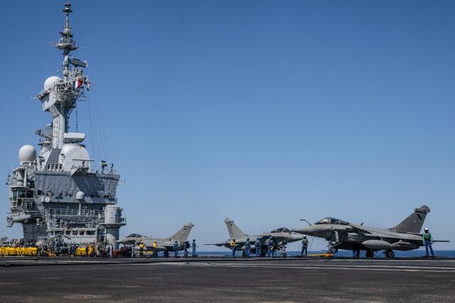 (FILES) This photograph taken on April 27, 2026, shows Rafale fighter aircraft parked on the flight deck of the French aircraft carrier Charles de Gaulle during the NATO military exercise Neptune Strike 26-2, off the coast of the Greek island of Crete. France's aircraft carrier the Charles de Gaulle was on May 6, 2026,  heading towards the southern Red Sea to pre?position for a possible mission to restore navigation in the Strait of Hormuz, the presidency said. (Photo by Angelos TZORTZINIS / AFP)