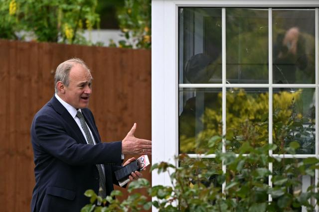 Britain's Liberal Democrat party leader Ed Davey speaks to a member of the public as the party canvases voters in Redhill, Surrey, south of London on May 6, 2026, a day before British local elections. British voters head to the polls on May 7 for local elections set to pile more misery on unpopular Labour Prime Minister Keir Starmer and cement the rise of right- and left-wing populists. (Photo by JUSTIN TALLIS / AFP)