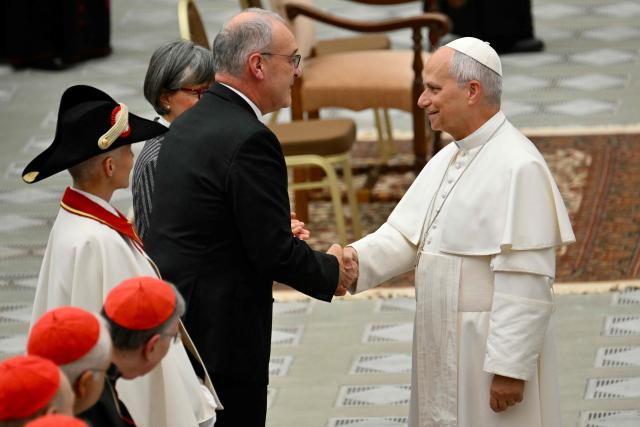 Swiss President Guy Parmelin shakes hands with Pope Leo XIV during a swearing-in ceremony for 28 new Swiss Guard recruits at the Paul VI audience hall in the Vatican on May 6, 2026. (Photo by Alberto PIZZOLI / AFP)