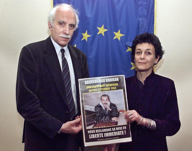 Erik Jurgens (L), member of the Committee on Legal Affairs and Human Rights of the Parliamentary Assembly of the Council of Europe and Isabelle Coutant-Peyre, the lawyer of the Algerian Abdelhamid Hakkar, hold a portrait of Abdelhamid Hakkar during a press conference in Paris on February 14, 2000. Abdelhamid Hakkar, a figure in organised crime who was released from prison in 2012 after 27 years of imprisonment, has died in Besançon where he resided, AFP learned from the city hall on May 6, 2026. (Photo by Patrick HERTZOG / AFP)
