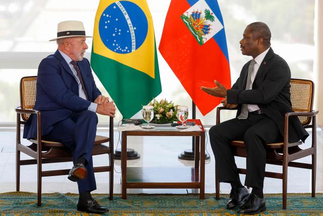 Brazilian President Luiz Inacio Lula da Silva (L) speaks with the Ambassador of Haiti, Jean-Victor Harvel Jean-Baptiste, during a ceremony for the presentation of credentials by new foreign ambassadors to Brazil, at the Planalto Palace, in Brasilia, on May 6, 2026. (Photo by Sergio Lima / AFP)
