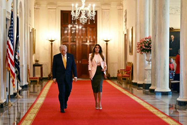 US President Donald Trump and First Lady Melania Trump walk toward the East Room to participate in a Military Mother's Day Event at the White House in Washington, DC, on May 6, 2026. (Photo by Kent NISHIMURA / AFP)
