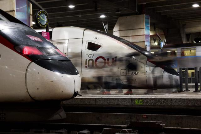 (FILES) This photograph taken with slow shutter speed on February 16, 2024 shows passengers walking on a platform to embark an InOui high-speed TGV train at the Gare Montparnasse station amid a ticket controller strike in Paris. The four representative unions at SNCF announced on May 6, 2026 a joint call for a strike on June 10, to protest against the rail group’s "reorganizations," which are causing "human tragedies" among railway workers. (Photo by Ian LANGSDON / AFP)