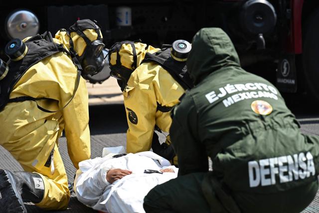Rescue teams assist a simulated victim of a chemical-biological contaminant leak during an earthquake drill in Mexico City on May 6, 2026. (Photo by Yuri CORTEZ / AFP)