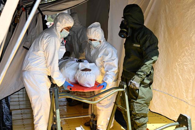 Rescue teams assist a simulated victim of a chemical-biological contaminant leak during an earthquake drill in Mexico City on May 6, 2026. (Photo by Yuri CORTEZ / AFP)
