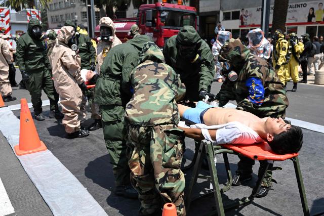 Rescue teams of the Mexican Navy and Army evacuate simulated victims from a supposedly collapsed building at the Plaza del Monumento a la Revolucion during an earthquake drill in Mexico City on May 6, 2026. (Photo by Yuri CORTEZ / AFP)