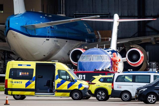 This photograph shows a person in a white hazmat suit (Centre L) disembarking a Bombardier Challenger 605 medical aircraft allegedly carrying some of the passengers believed to be infected with hantavirus from the cruise ship MV Hondius, before being escorted to an ambulance at Schiphol Airport in Amsterdam on May 6, 2026. A plane that left Cape Verde following the evacuation of a cruise ship hit by the hantavirus landed in Spain's Canary Islands on May 6, while a second flight headed for the Netherlands. (Photo by Jeffrey Groeneweg / ANP / AFP) / Netherlands OUT