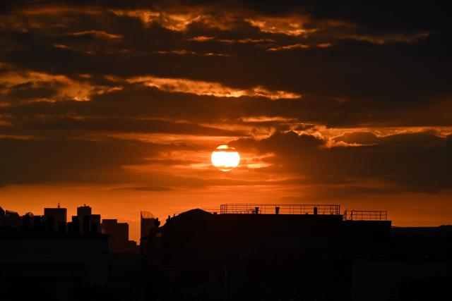 The sun sets on a cloudy sky over Paris on May 6, 2026. (Photo by Christophe DELATTRE / AFP)