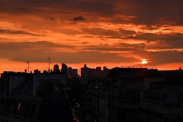 This photograph taken from Paris shows a sunset on a cloudy sky over La Defense on May 6, 2026. (Photo by Christophe DELATTRE / AFP)