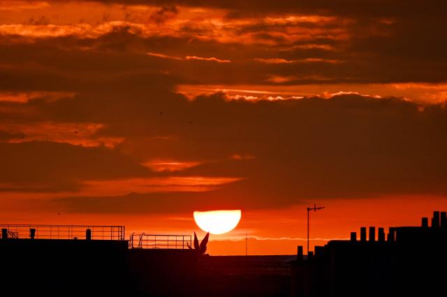The sun sets on a cloudy sky over Paris on May 6, 2026. (Photo by Christophe DELATTRE / AFP)