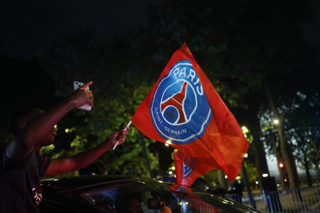 A Paris Saint-Germain (PSG) supporter celebrates their team's progression to the Final of the UEFA Champions League near the Champs-Elysees after their second-leg semi-final football match against Bayern Munich, in Paris, on May 6, 2026. The holders set up a Champions League final against Arsenal after a 1-1 second-leg draw at Bayern Munich secured a 6-5 aggregate victory. (Photo by SIMON WOHLFAHRT / AFP)