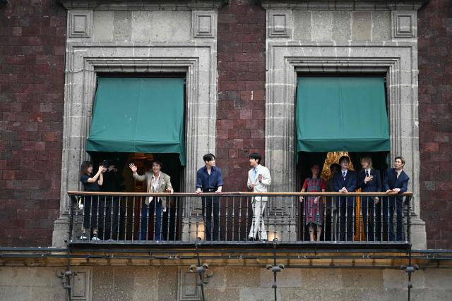 South Korean K-pop band BTS stand at the balcony of the National Palace, at Zocalo square in Mexico City on May 6, 2026. BTS will hold three sold-out shows at Estadio GNP Seguros in Mexico city on May 7, 9, and 10. (Photo by YURI CORTEZ / AFP)