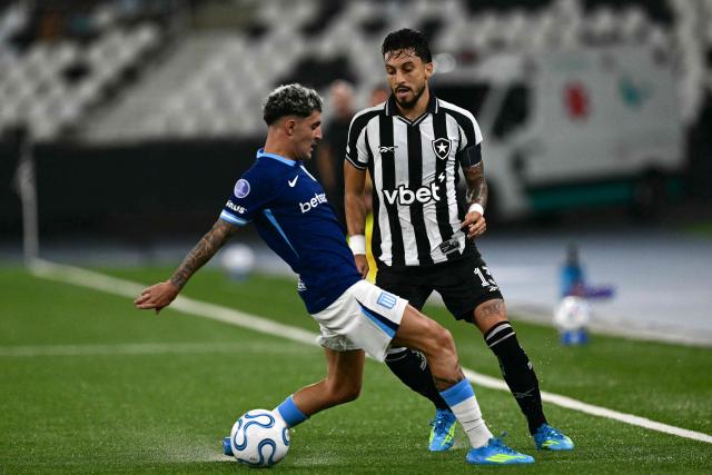 Racing's Uruguayan defender #15 Gaston Martirena and Botafogo's defender #13 Alex Telles fight for the ball during the Copa Sudamericana group stage football match between Brazil's Botafogo and Argentina's Racing Club at the Nilton Santos stadium in Rio de Janeiro, Brazil on May 6, 2026. (Photo by Pablo PORCIUNCULA / AFP)