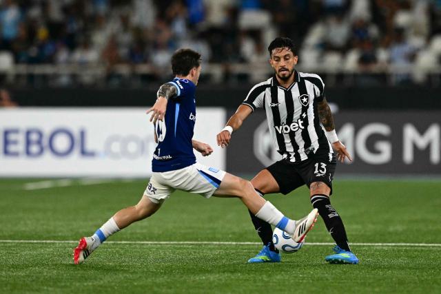 Racing's midfielder #13 Santiago Sosa and Botafogo's defender #13 Alex Telles fight for the ball during the Copa Sudamericana group stage football match between Brazil's Botafogo and Argentina's Racing Club at the Nilton Santos stadium in Rio de Janeiro, Brazil on May 6, 2026. (Photo by Pablo PORCIUNCULA / AFP)