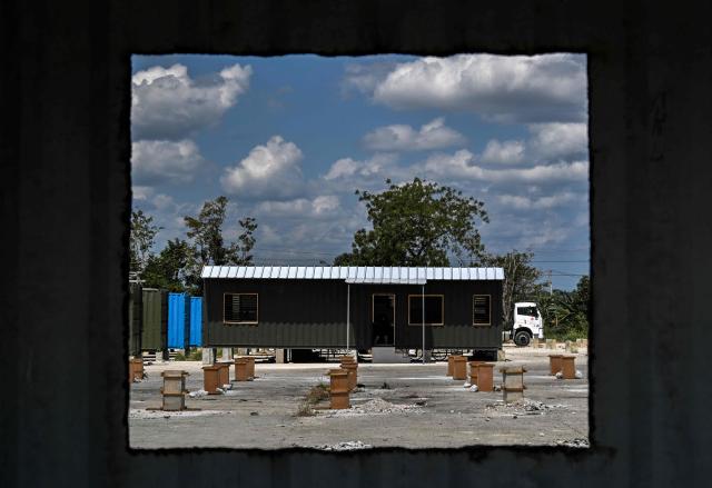 A housing unit made from a shipping container is seen through a window of another unit at a construction site in Havana on May 7, 2026. Amid a housing deficit exceeding 800,000 homes, Cuba has begun converting shipping containers into housing units. Initially intended to transport equipment for solar parks, these metal modules are now being adapted as homes for vulnerable groups, including families affected by climate events, recipients of state subsidies and young people without family support. (Photo by YAMIL LAGE / AFP)