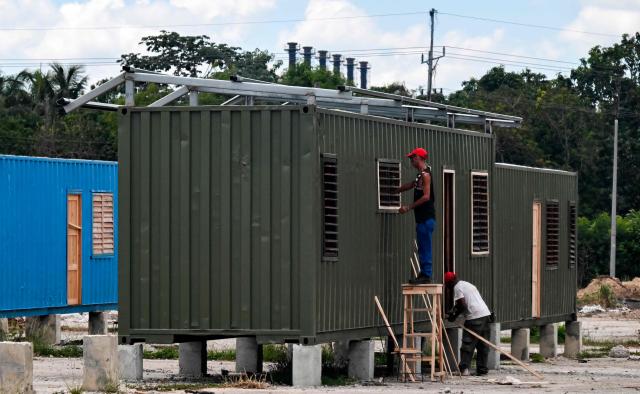 Workers carry out construction work on a housing unit made from a shipping container in Havana on May 6, 2026. Amid a housing deficit exceeding 800,000 homes, Cuba has begun converting shipping containers into housing units. Initially intended to transport equipment for solar parks, these metal modules are now being adapted as homes for vulnerable groups, including families affected by climate events, recipients of state subsidies and young people without family support. (Photo by YAMIL LAGE / AFP)