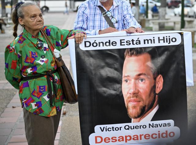 Carmen Nava poses next to an image of her son, political prisoner Victor Quero Navas in Caracas on April 30, 2026. Venezuela acknowledged on May 7, 2026, the death of Quero Navas, nine months after his passing, the Ministry of Penitentiary Services reported in a statement. (Photo by Maryorin Mendez / AFP)