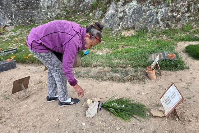 Carmen Nava places flowers at the grave of her son, political prisoner Victor Quero Navas, in a cemetery in Caracas on May 7, 2026. Venezuela acknowledged on May 7, 2026, the death of Quero Navas, nine months after his passing, the Ministry of Penitentiary Services reported in a statement. (Photo by Maryorin Mendez / AFP)