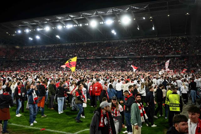 SC Freiburg's fans celebrate on the pitch after Freiburg's 3-1 win in the UEFA Europa League semi-final second leg football match between SC Freiburg and SC Braga in Freiburg im Breisgau, southwestern Germany on May 7, 2026. Lukas Kuebler scored in each half as Freiburg beat Braga 3-1 at home on May 7 to win 4-3 on aggregate and and qualify for the Europa League final where they will face Aston Villa. (Photo by Silas STEIN / AFP)