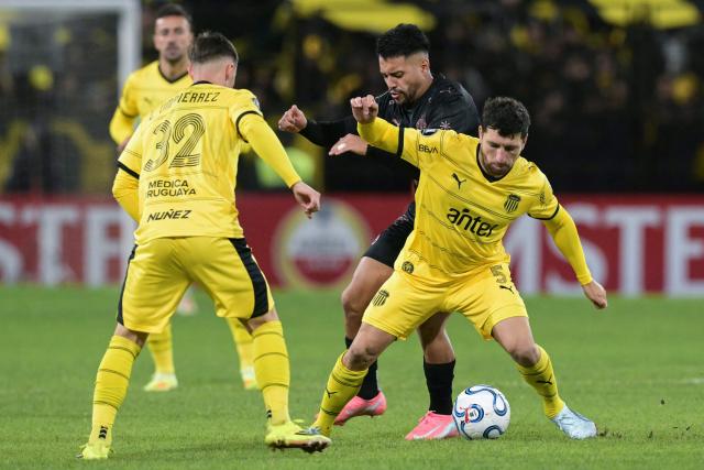 Penarol's Argentine midfielder #05 Eric Remedi (R) and Platense's midfielder #15 Franco Amarfil fight for the ball past Penarol's midfielder #32 Leandro Umpierrez during the Copa Libertadores group stage football match between Argentina's Platense and Uruguay's Penarol at the Ciudad de Vicente Lopez stadium in Vicente Lopez, Buenos Aires province, Argentina on May 7, 2026. (Photo by JUAN MABROMATA / AFP)