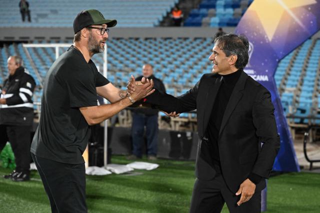 Boston River's head coach Ignacio Ithurralde (L) and Millonarios' head coach Fabian Bustos greet during the Copa Sudamericana group stage football match between Uruguay's Boston River and Colombia's Millonarios at the Centenario stadium in Montevideo on May 7, 2026. (Photo by EITAN ABRAMOVICH / AFP)