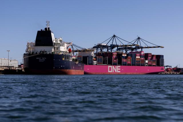 (FILES) Singaporean oil tanker “Great Thita” (L) is moored at the port of Los Angeles, on April 11, 2026. A US trade court on Thursday dealt President Donald Trump a fresh setback, ruling against the 10-percent global tariffs he instituted after the Supreme Court struck down many earlier duties. (Photo by ETIENNE LAURENT / AFP)