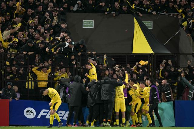 Penarol's forward #09 Facundo Batista (C) celebrates with fans afyer scoring his team's first goal during the Copa Libertadores group stage football match between Argentina's Platense and Uruguay's Penarol at the Ciudad de Vicente Lopez stadium in Vicente Lopez, Buenos Aires province, Argentina on May 7, 2026. (Photo by JUAN MABROMATA / AFP)
