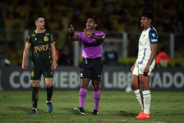 Venezuelan referee Alexis Herrera gestures flaked by Mirassol's midfielder #07 Shaylon and Liga de Quito's defender #44 Luis Segoviaduring the Copa Libertadores group stage football match between Brazil's Mirassol and Ecuador's Liga de Quito at the Jose Maria de Campos Maia stadium in Mirassol, state of Sao Paulo, Brazil on May 7, 2026. (Photo by RAPHA MARQUES / AFP)