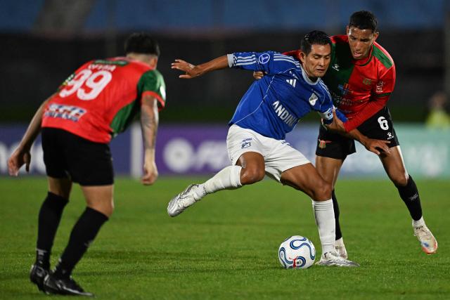 Millonarios' midfielder #14 David Silva (C) and Boston River's Venezuelan midfielder #6 Andres Romero fight for the ball during the Copa Sudamericana group stage football match between Uruguay's Boston River and Colombia's Millonarios at the Centenario stadium in Montevideo on May 7, 2026. (Photo by Eitan ABRAMOVICH / AFP)
