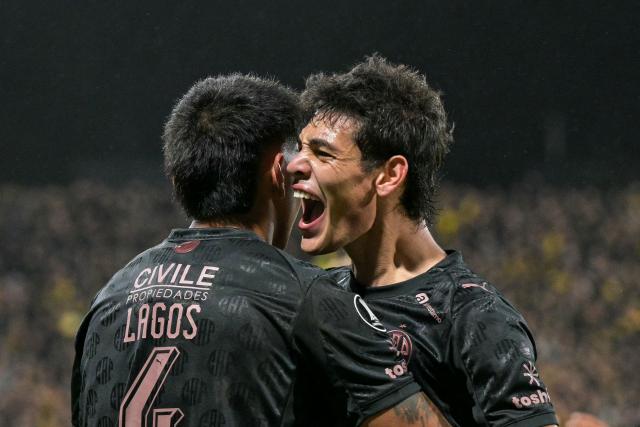 Platense's defender #04 Agustin Lagos celebrates with teammate midfielder #10 Franco Zapiola after scoring his team's first goal during the Copa Libertadores group stage football match between Argentina's Platense and Uruguay's Penarol at the Ciudad de Vicente Lopez stadium in Vicente Lopez, Buenos Aires province, Argentina on May 7, 2026. (Photo by JUAN MABROMATA / AFP)