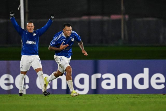 Millonarios' Argentine forward #27 Rodrigo Contreras (R) celebrates after scoring his team's third goal during the Copa Sudamericana group stage football match between Uruguay's Boston River and Colombia's Millonarios at the Centenario stadium in Montevideo on May 7, 2026. (Photo by Eitan ABRAMOVICH / AFP)
