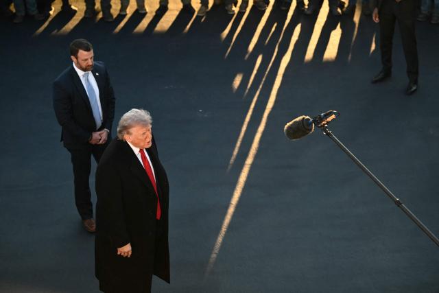 US President Donald Trump, flanked by US Secretary of Homeland Security Markwayne Mullin,  speaks with workers who have been painting the Lincoln Memorial Reflecting Pool in Washington, DC, on May 7, 2026. Workers have been resurfacing the bottom of Washington's famous Lincoln Memorial Reflecting Pool with "American flag blue"-colored material used in swimming pools, following an order by US President Donald Trump. (Photo by Kent NISHIMURA / AFP)