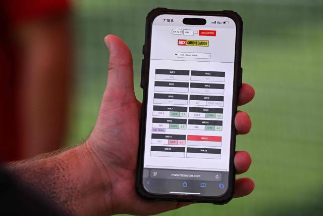 Coach Zachary Beardsley shows a player’s weight log, which is updated each week and from which points are counted in the “Man vs Fat Soccer” weight-loss program, in Houston, Texas, on May 5, 2026. In a soccer league of big men trying to lose weight, the five-a-side teams feature names like OB City, Big Bananas and Heavy Touch FC. And players can score before the game even starts, standing on a scale and winning goal points for chipping away at their weight problems. Welcome to Man vs. Fat Soccer, a tongue in cheek Texas league that is thriving as Houston prepares to join cities elsewhere in the United States in hosting World Cup games, along with Mexico and Canada. (Photo by RONALDO SCHEMIDT / AFP)