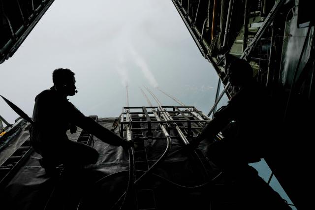 (FILES) Royal Malaysian Air Force personnel start the cloud seeding process during a flight from the military base in Subang to the state of Kedah on September 19, 2019. Malaysia is resorting to cloud seeding to bring much-needed rain to the country's "rice bowl" north, where a drought has delayed planting of the staple crop and raised supply fears. (Photo by SADIQ ASYRAF / AFP)