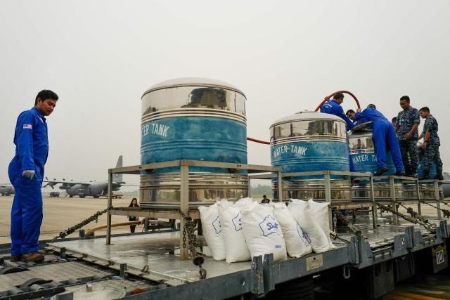 (FILES) Authorities mix sodium chloride and water in a cloud seeding process at the Royal Malaysian Air Force Military Base in Subang on September 19, 2019. Malaysia is resorting to cloud seeding to bring much-needed rain to the country's "rice bowl" north, where a drought has delayed planting of the staple crop and raised supply fears. (Photo by SADIQ ASYRAF / AFP)