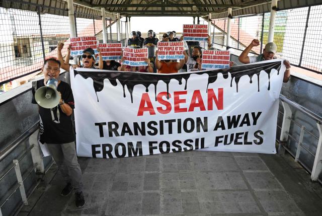 Environmental activists hold placards as they shout slogans during a rally on a footbridge coinciding with the opening ceremony of the Association of Southeast Asian Nations (ASEAN)summit in Cebu on May 8, 2026. (Photo by Ted ALJIBE / AFP)