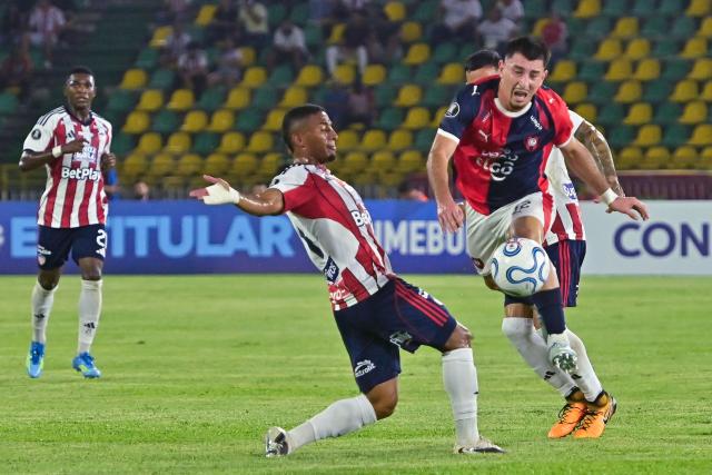 Junior's defender #03 Edwin Herrera (L) and Cerro Porteno's midfielder #32 Cesar Bobadilla fight for the ball during the Copa Libertadores group stage football match between Colombia's Junior and Paraguay's Cerro Porteno at the Olimpico Jaime Moron Leon stadium in Cartagena, Bolivar department, Colombia on May 7, 2026. (Photo by Manuel PEDRAZA / AFP)