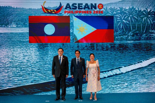 Laos Prime Minister Sonexay Siphandone (L) poses for a photo with Philippine President Ferdinand Marcos Jr. and Liza Araneta Marcos during a welcome ceremony for the 48th Association of Southeast Asian Nations (ASEAN) summit in Cebu, central Philippines on May 8, 2026. (Photo by Ezra Acayan / POOL / AFP)